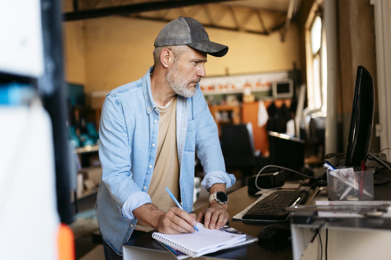 Travailleur consultant un ordinateur dans un atelier